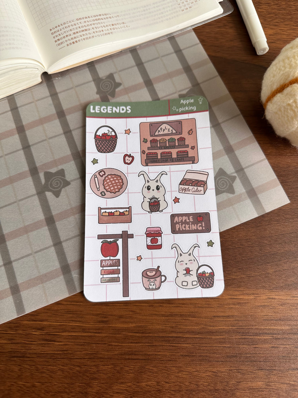 An apple picking theme sticker sheet on top of a wooden desk 