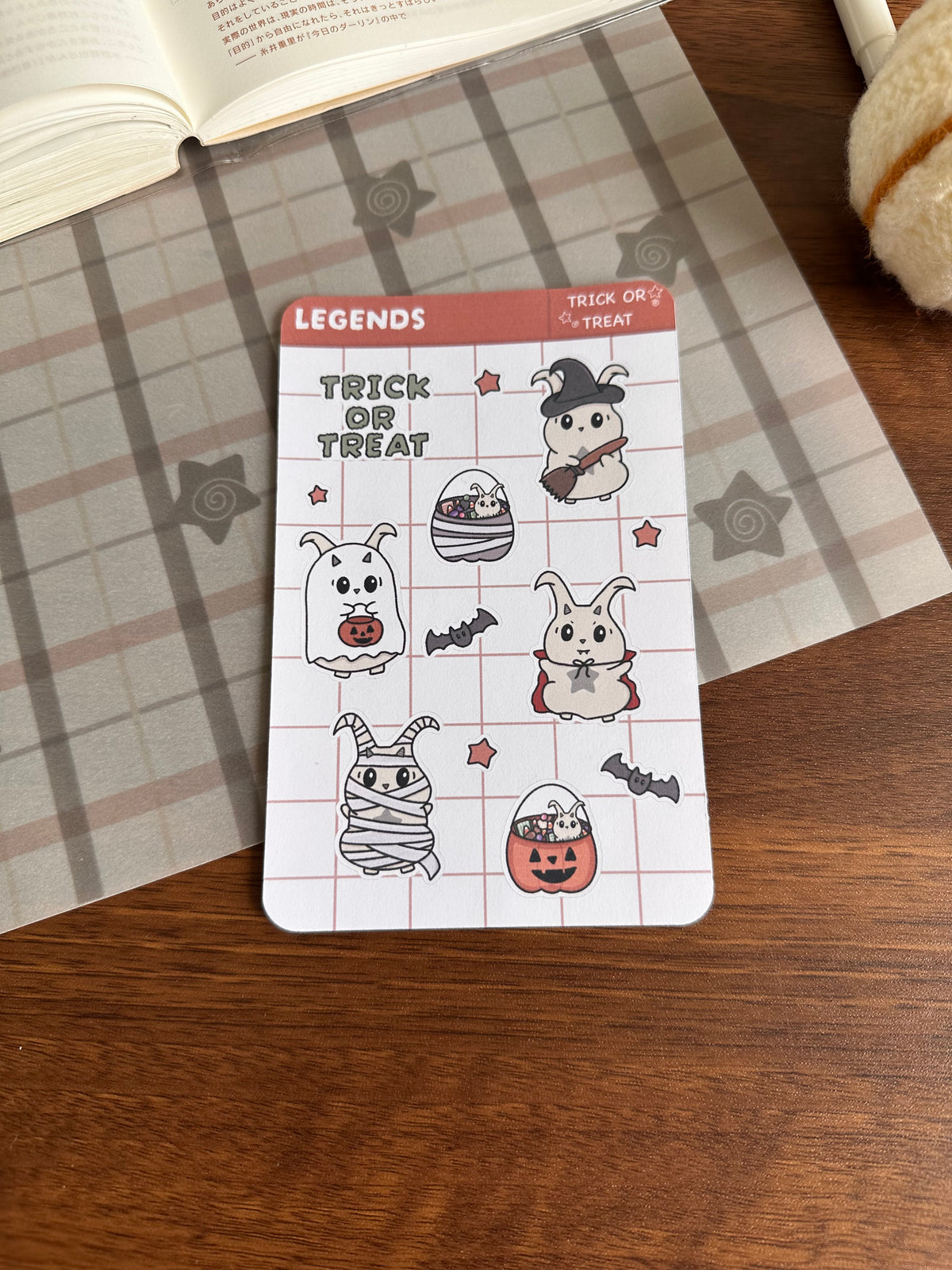 Halloween trick or treat sticker sheet on top of a wooden desk 