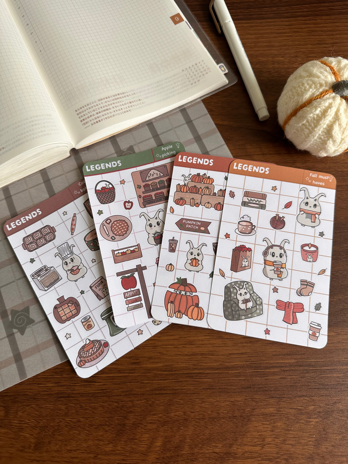 Different fall sticker sheets ( apple, pumpkin, must haves, and baking) on top of a desk 
