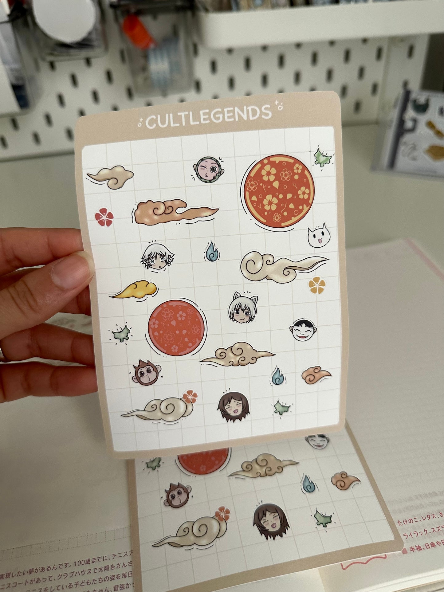 Sheet of stickers with various designs held by a hand, branded 'Cult Legends'.