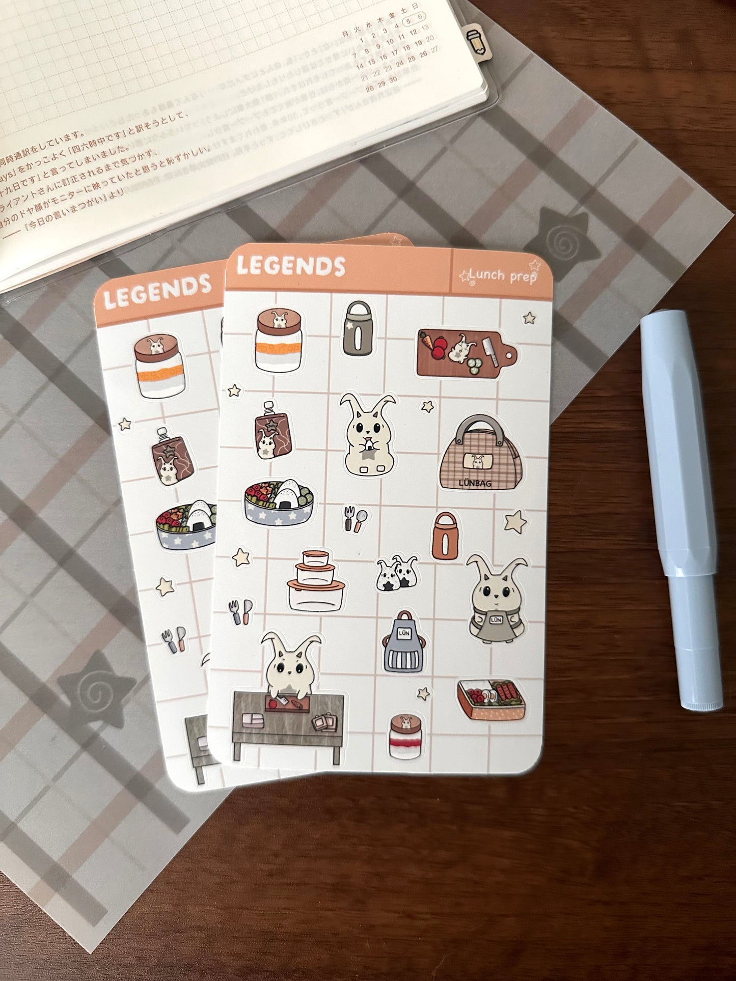 Lunch prep and meal prep sticker sheet on top of a wooden desk 