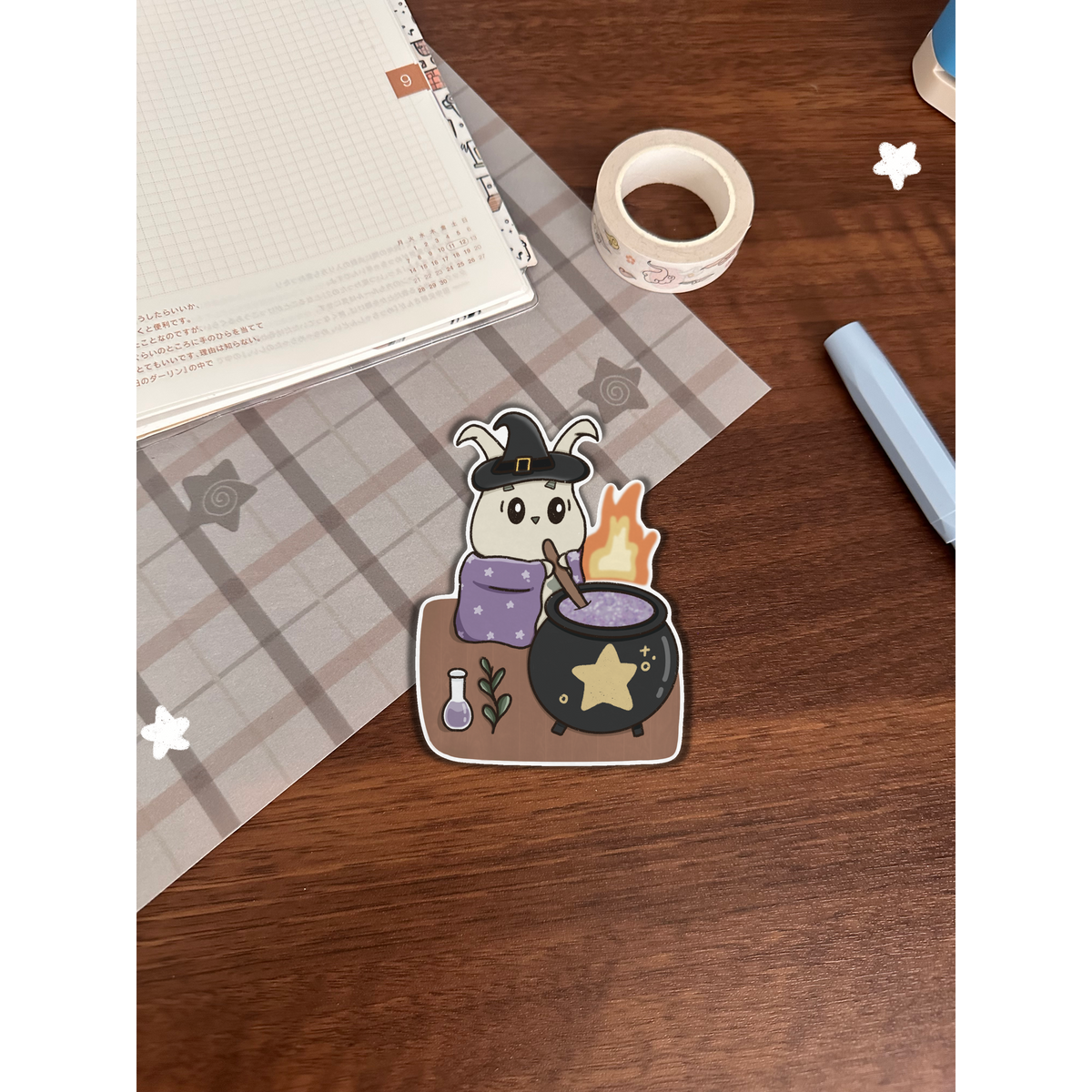 Witchy sticker with cauldron on a wooden table 