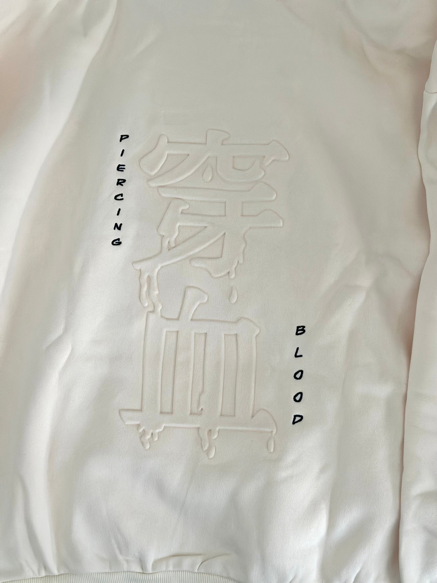 Embossing of “ piercing blood” written in Japanese and embroidered in English. 