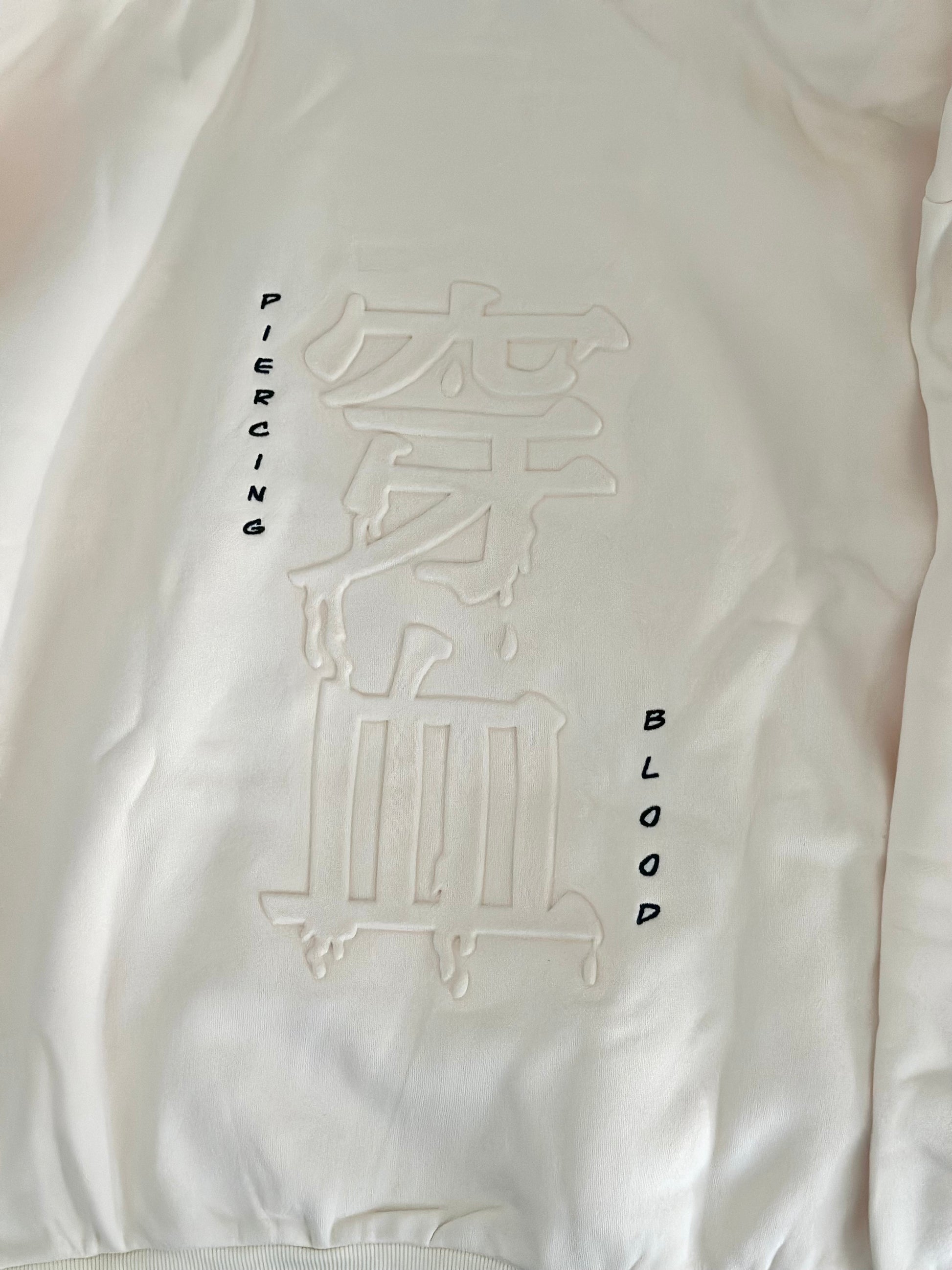 Embossing of “ piercing blood” written in Japanese and embroidered in English. 